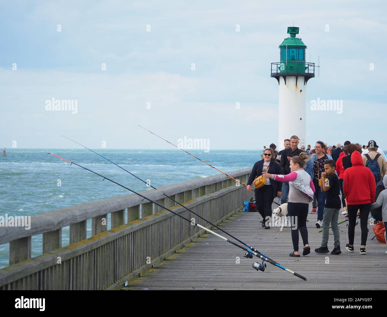 Pier/Gehweg, um den Leuchtturm bei der Einfahrt in den Hafen von Calais in Frankreich. Stockfoto