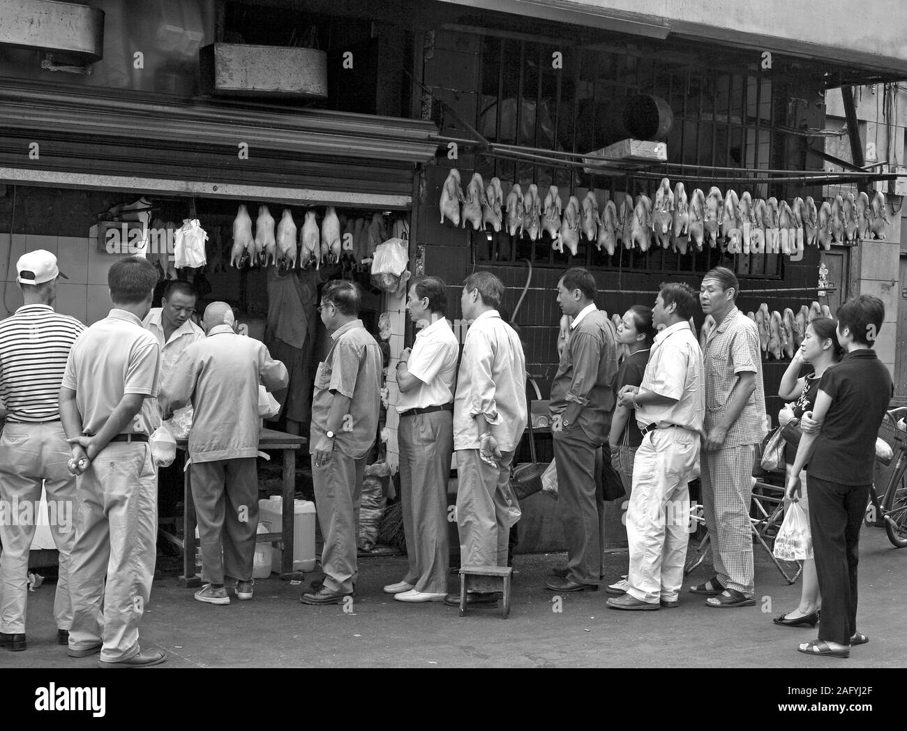 Das Leben auf der Straße in Shanghai, Shouning Lu. Kauf gegrillte Ente. Innerhalb kurzer Zeit wurde das Gebiet wird abgerissen, um Platz für zu machen'' werden die Entwicklung''. Stockfoto