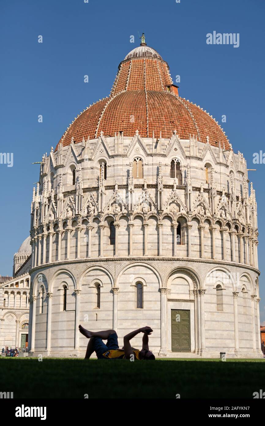 Im Sommer Touristen entspannen in der Piazza dei Miracoli mit dem Baptisterium von St. John/Baptisterium San Giovanni in Pisa Toskana Italien EU Stockfoto