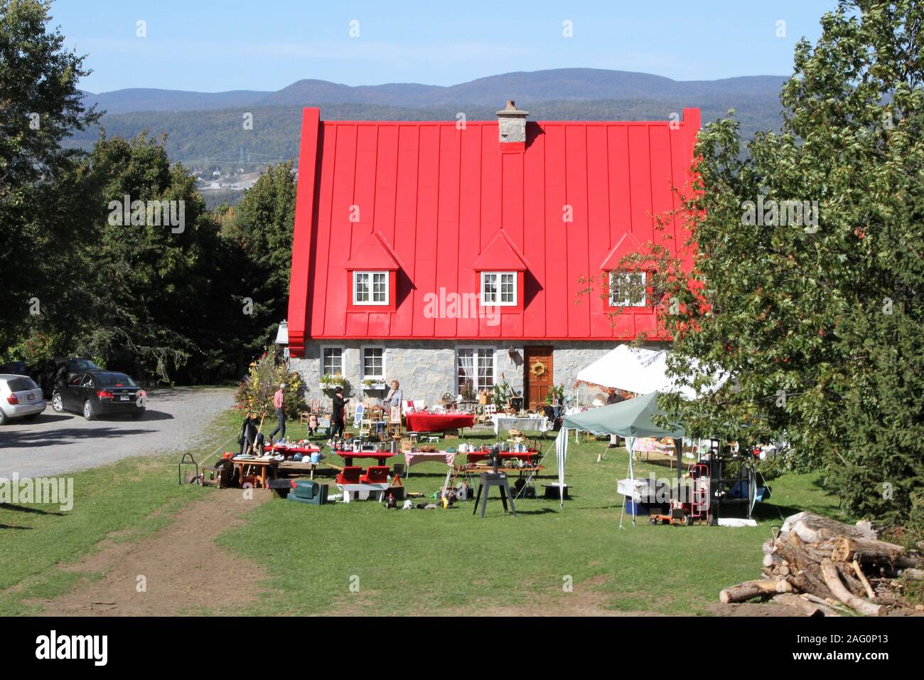 Yard Sale am Stein Haus mit rotem Dach Stockfoto