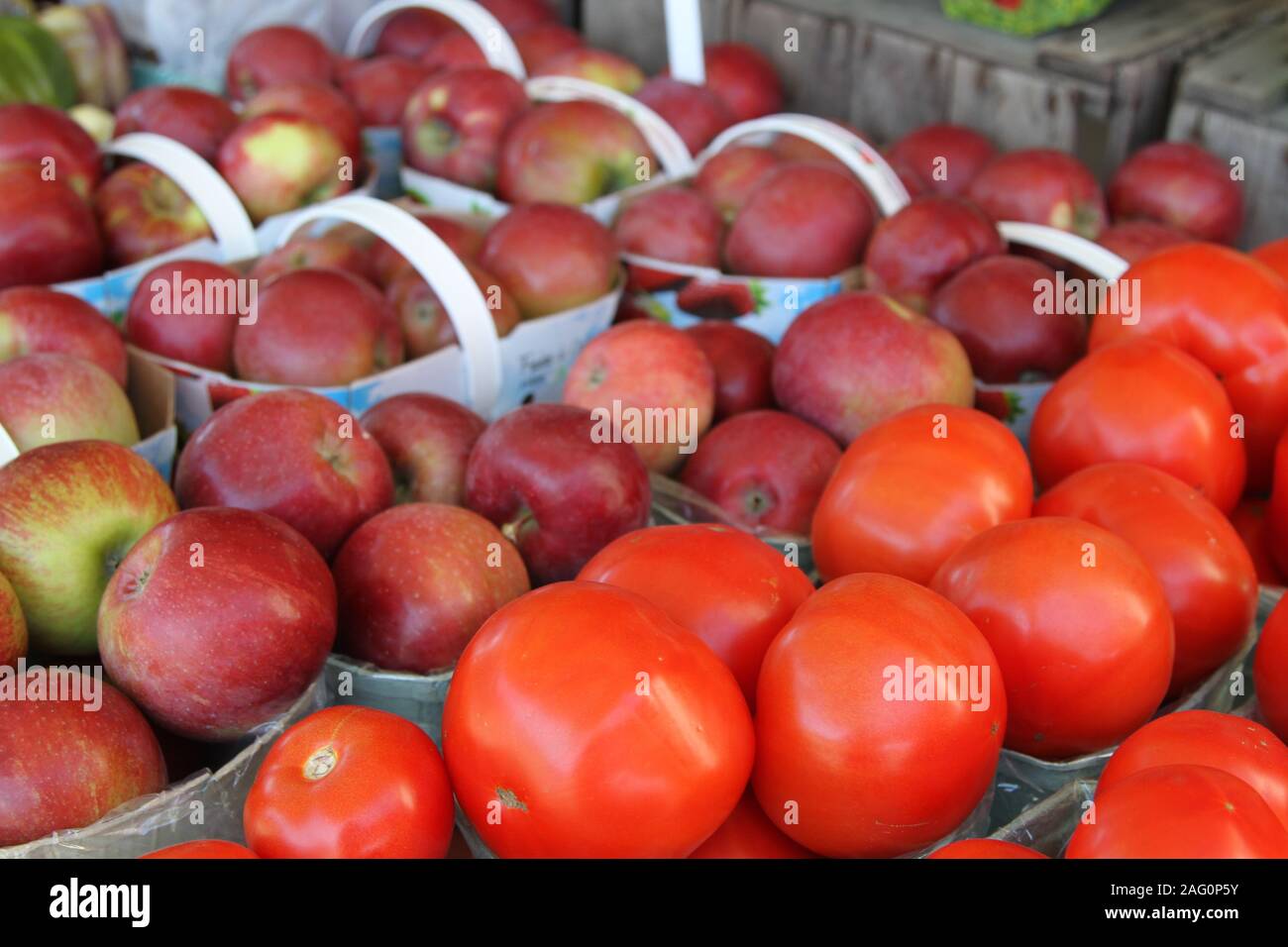 Tomaten und Äpfel in Körben mit Griffen Stockfoto