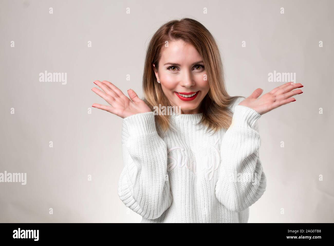 Bild von überrascht Frau mit Brille und in weißen Pullover über Hintergrund weiß gekleidet. An der Kamera Stockfoto