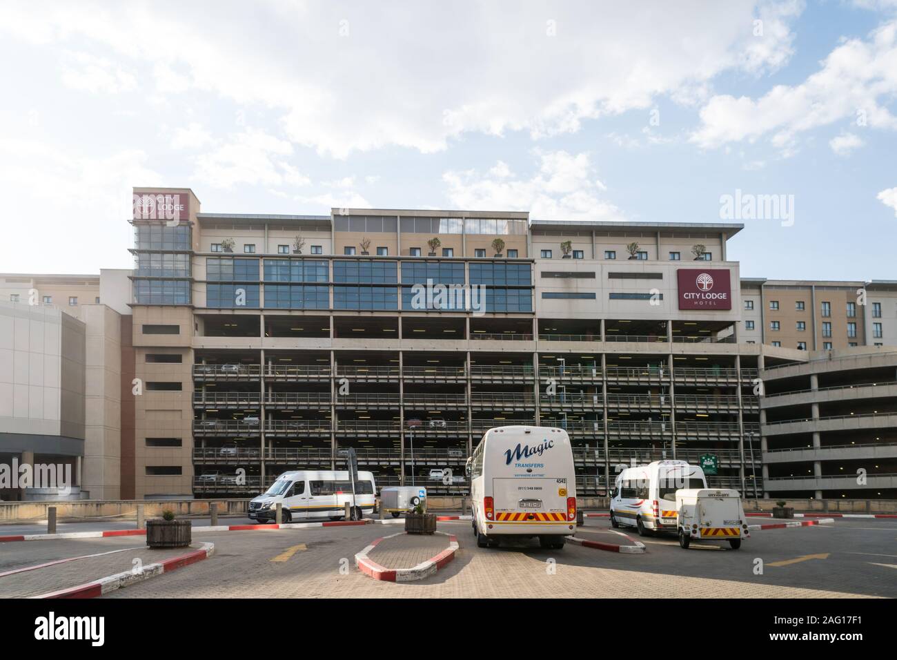 Mehrstöckiges Parkhaus mit City Lodge Hotel auf und zeigt verschiedene Hotel Transfer, Busse an OR Tambo Airport geparkt, Johannesburg Stockfoto
