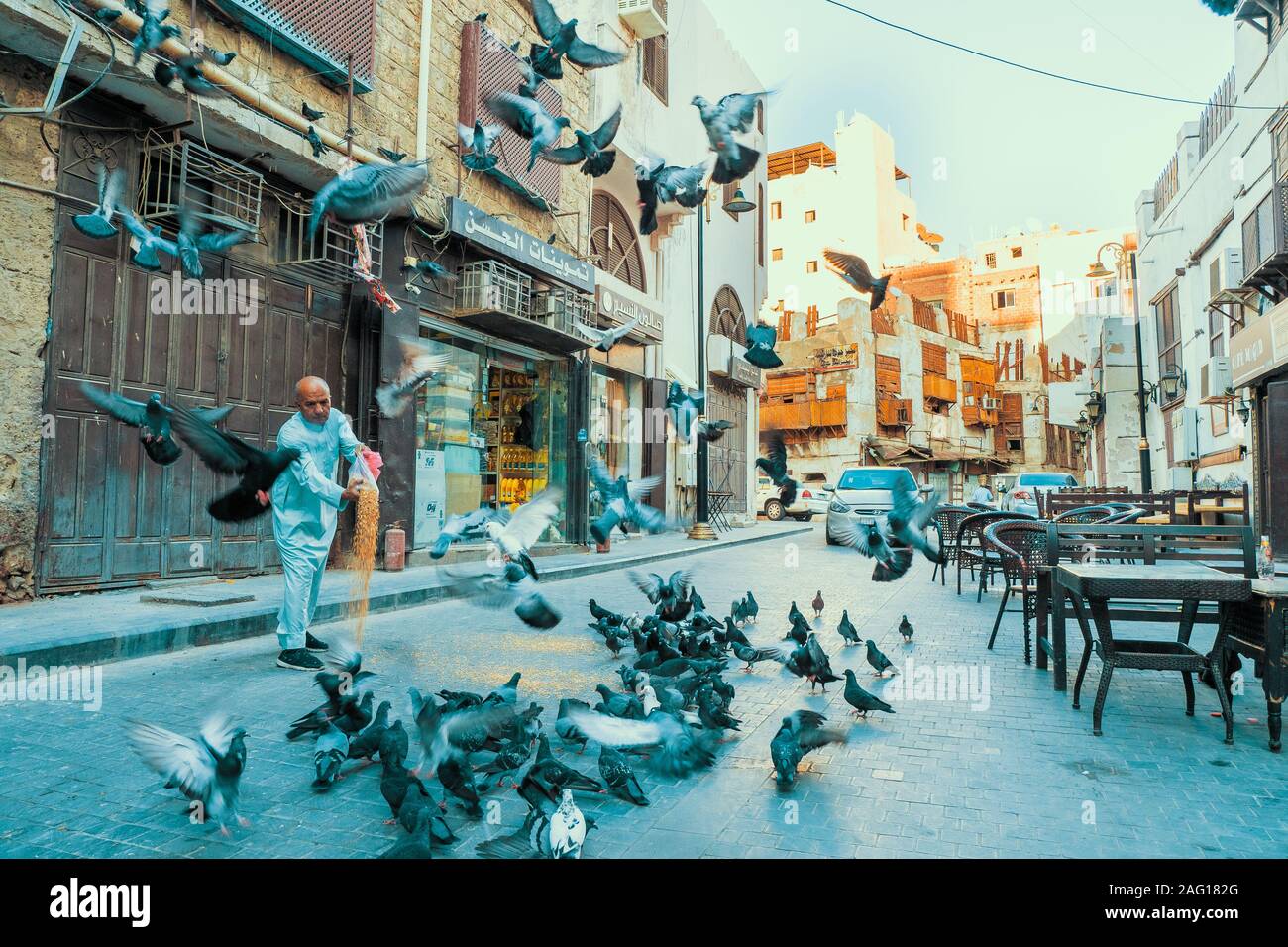 Arabisch senior füttern Tauben in einer Straße im historischen Bezirk Al Balad in Jeddah, KSA, Saudi-Arabien Stockfoto