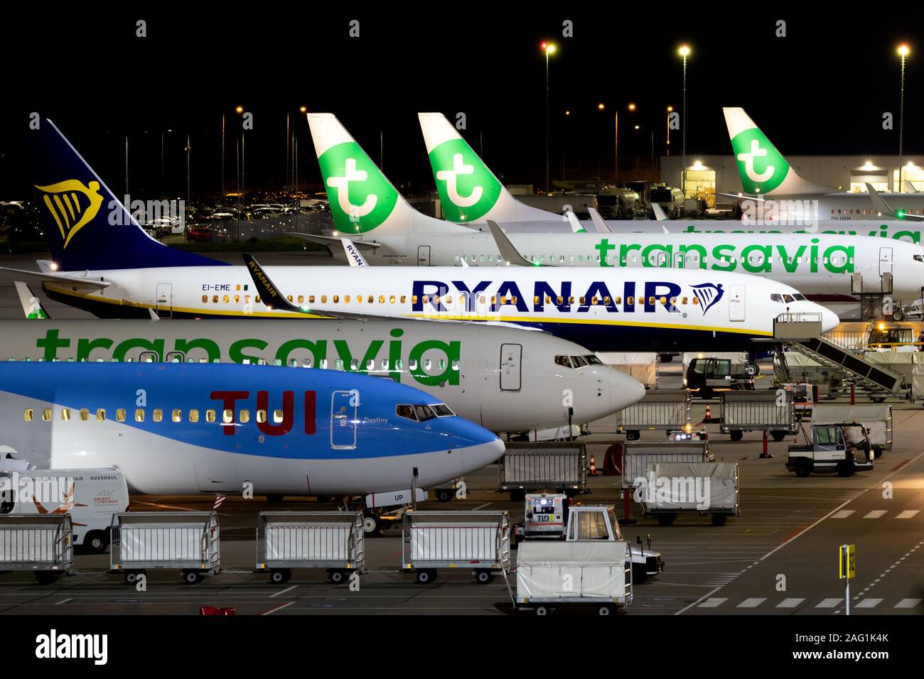 EINDHOVEN, Niederlande - 14.Oktober 2019: Nachtansicht des Low Budget Airlines Ryanair und Transavia Flugzeuge am Terminal von Eindhoven Airport geparkt Stockfoto