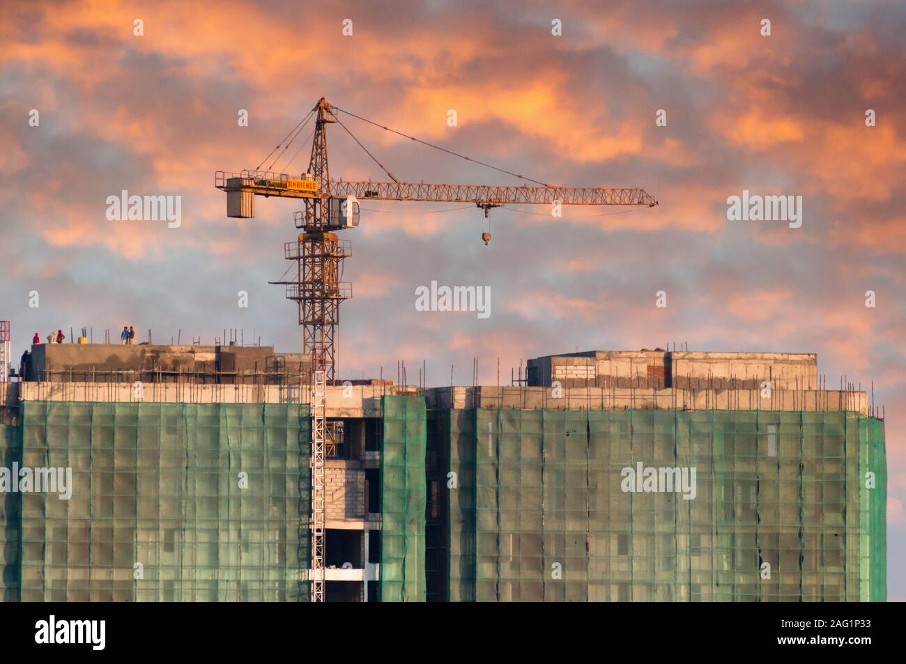 Im Bau Gebäude mit einem Kran auf der Oberseite und Sicherheitsnetze Stockfoto