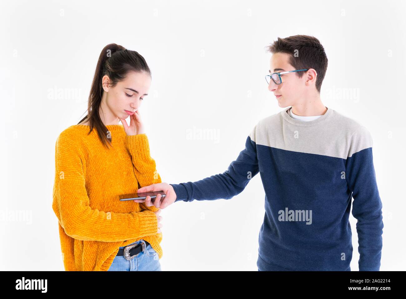 Teenager Hände sein Smartphone zu einem betroffenen Suchen teenage Mädchen auf einem hellen Hintergrund. Stockfoto
