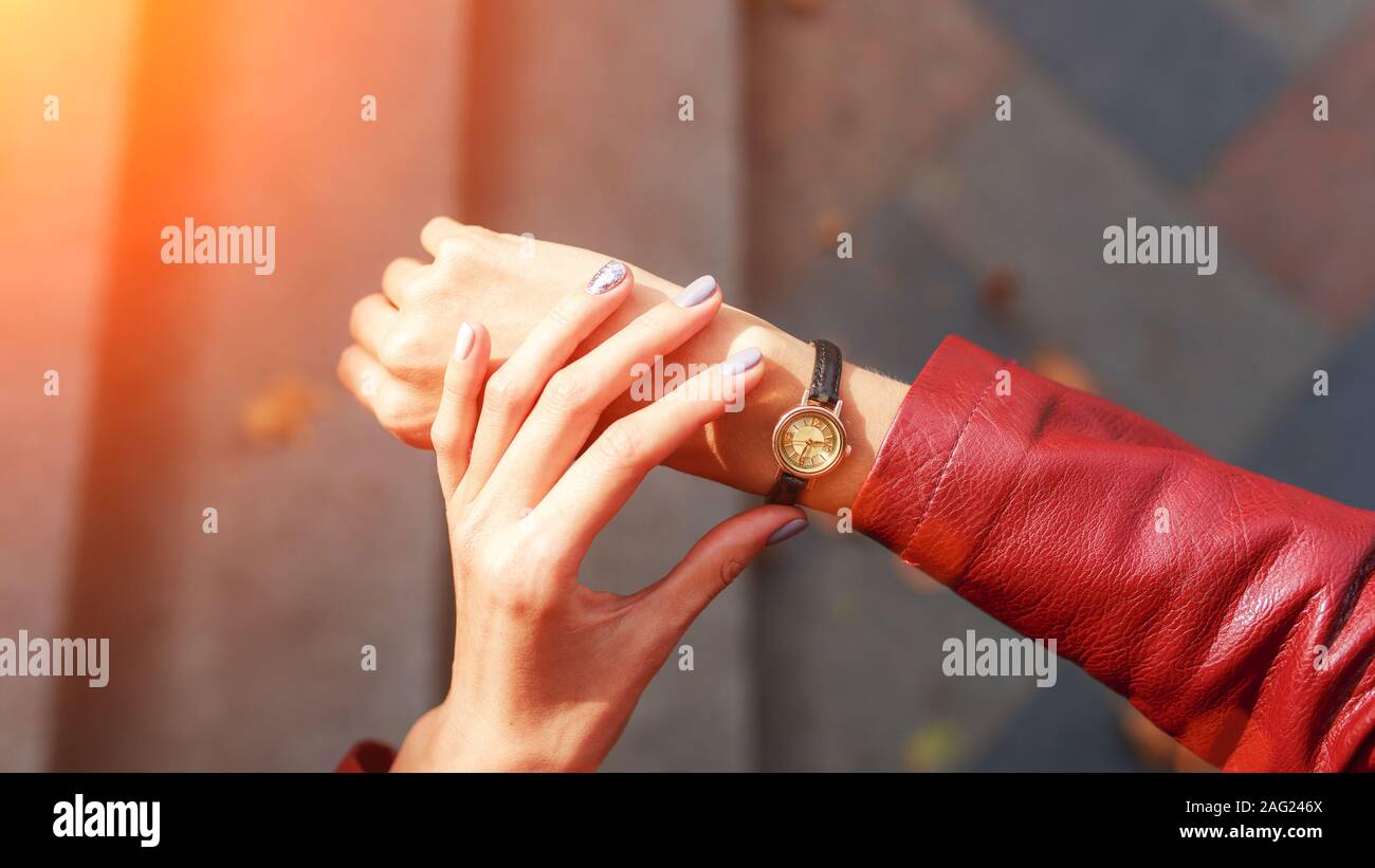 Street Style Fashion details., young Fashion Blogger trägt eine Jacke und eine analoge Armbanduhr. stilvolle Frau, die Zeit der Überprüfung auf ihre Uhr. Herbst Herbst Jahreszeit. Stockfoto