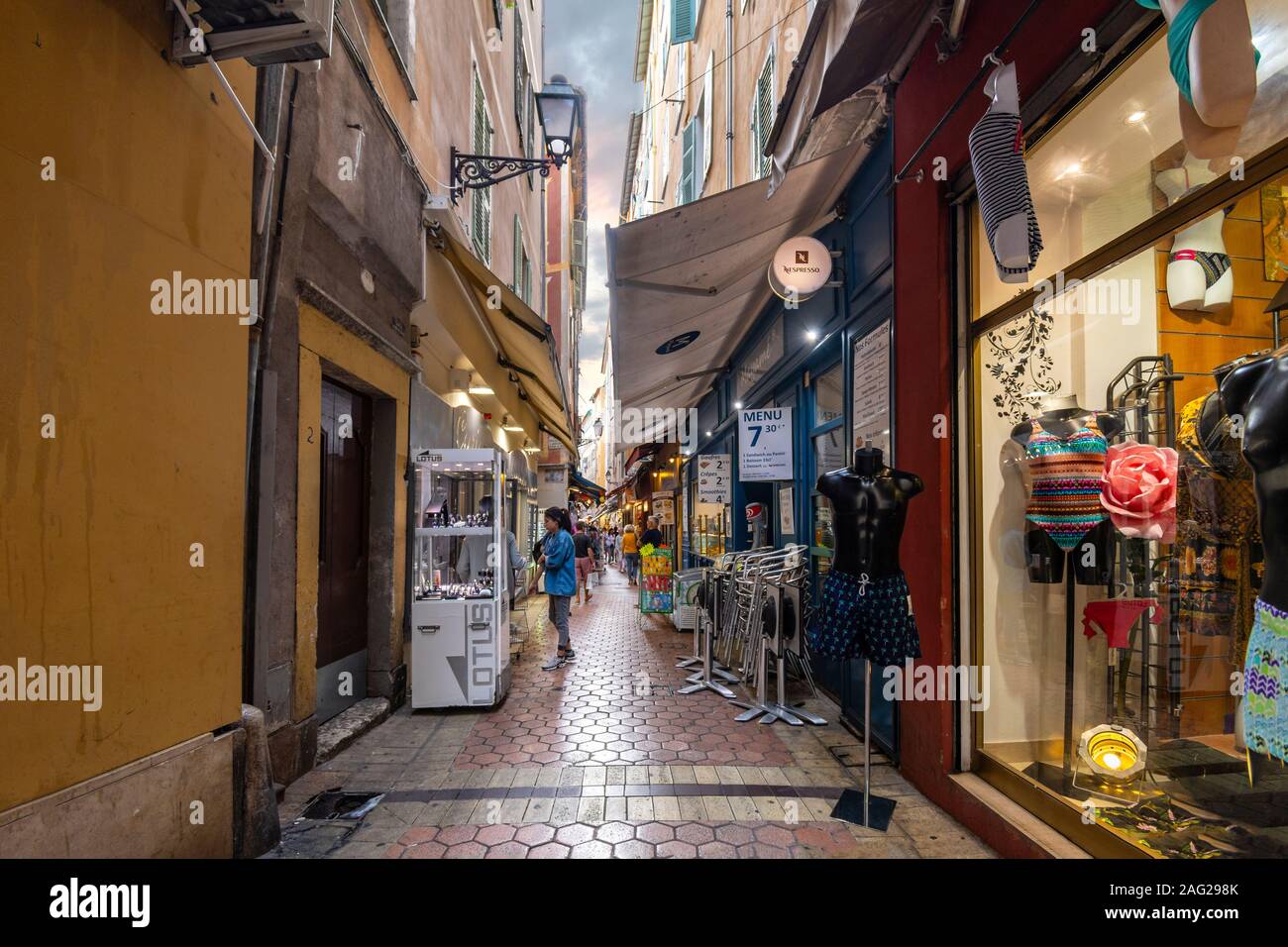 Touristen Shop eine sehr schmale Gasse voller Cafes und Geschäfte in der Altstadt von Nizza, Frankreich, an der Französischen Riviera. Stockfoto