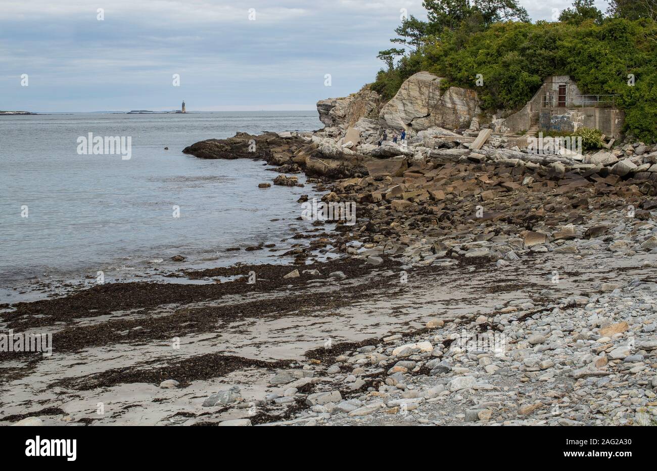 Einem kleinen, felsigen Strand auf dem Gelände von Fort Williams. Gleich um die Ecke ist Portland Head Lighthouse. Und Ram Island Leiste ist in der Ferne. Stockfoto