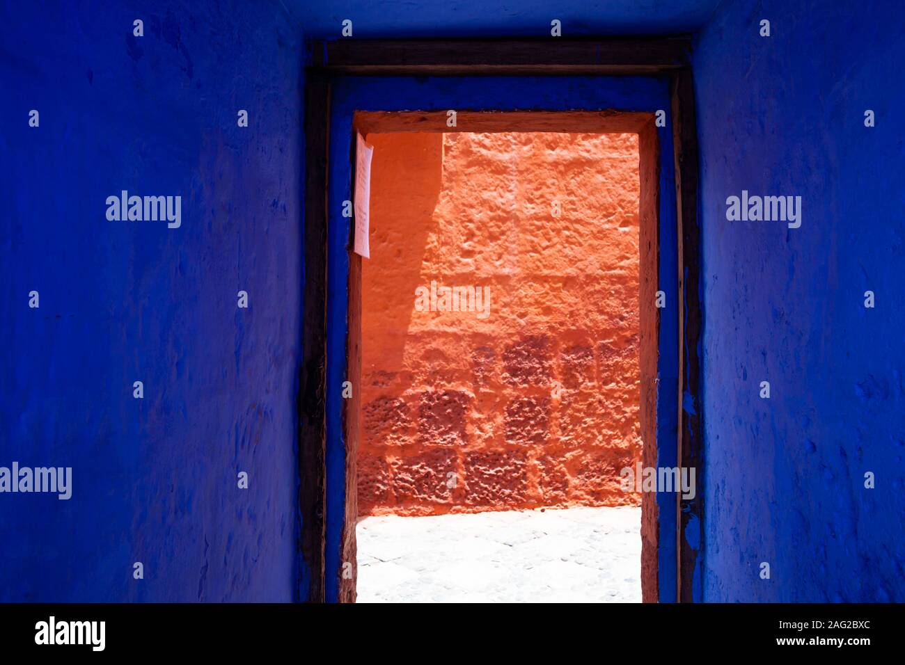 Blau, Indigo, Türöffnung mit Blick auf die rote Wand Stockfoto
