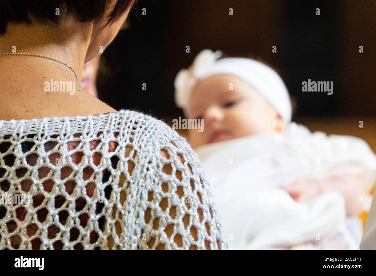 Kind in die Arme der Großmutter an eine Taufe Stockfoto