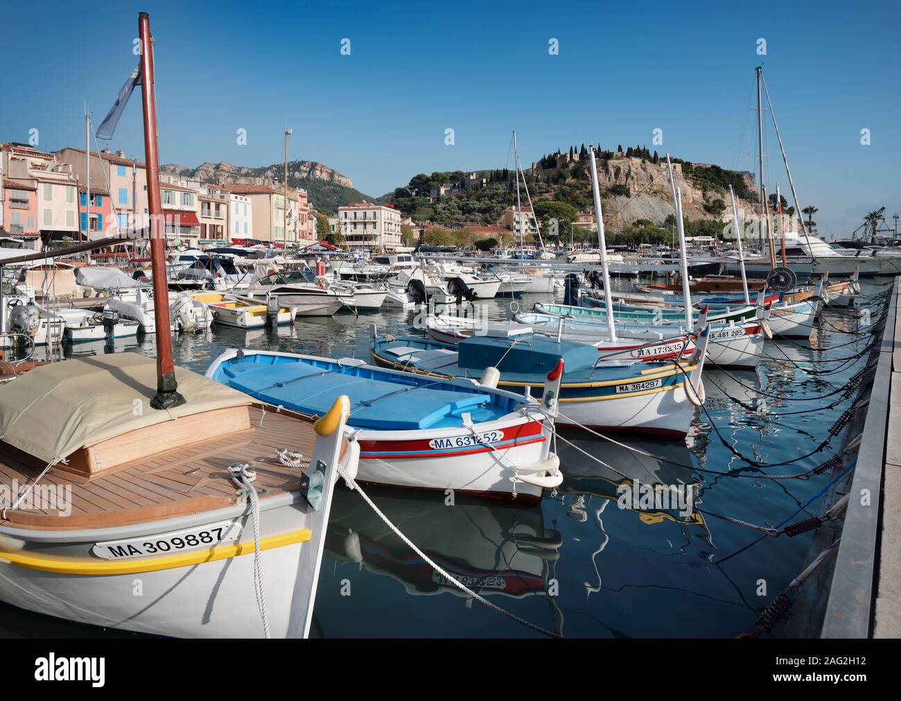 Boote angedockt in einem Kai von Cassis Hafen Stadt in Frankreich. Château de Cassis im Hintergrund. Cassis Reisefotografie. Stockfoto