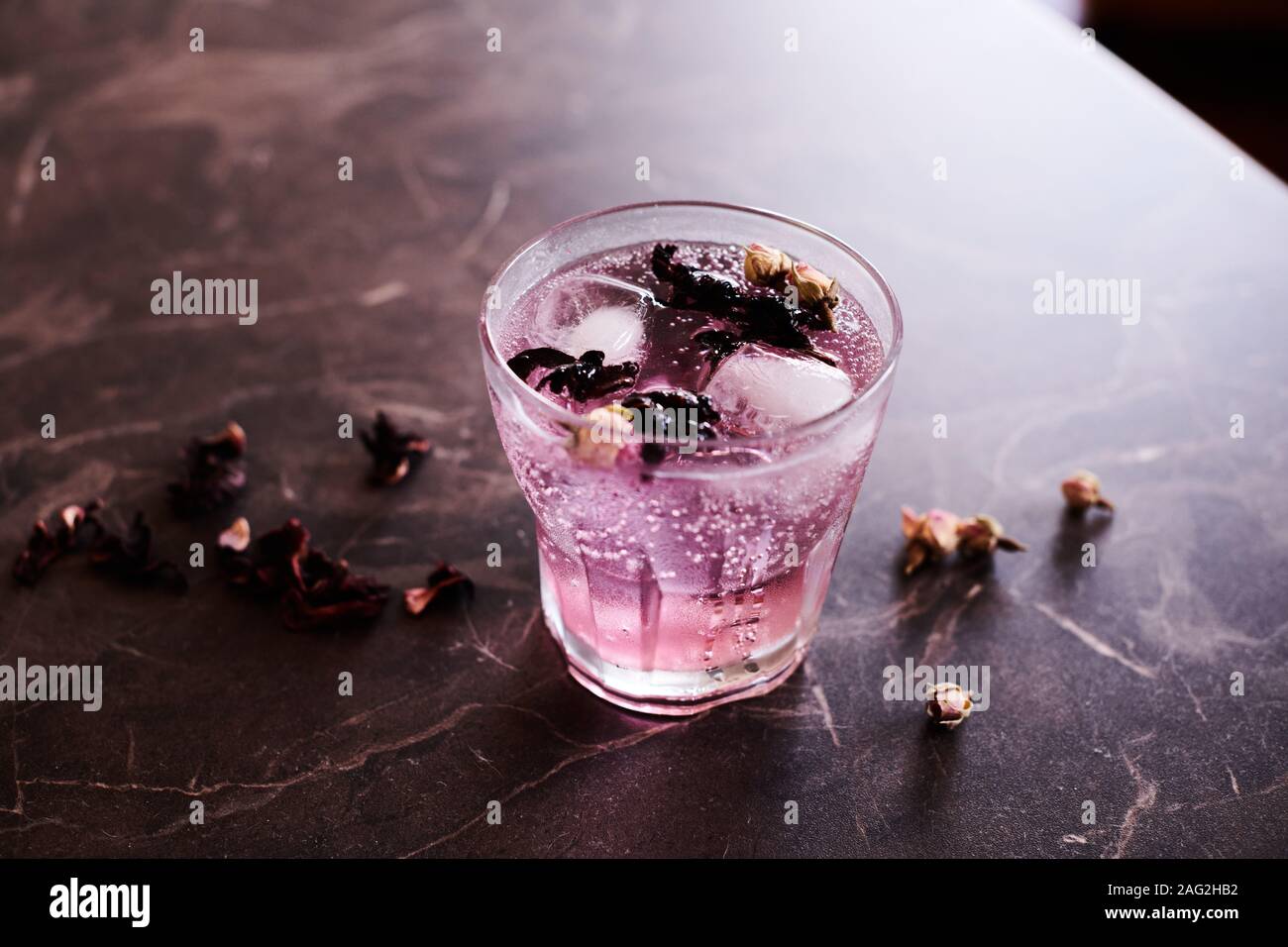 Pink Gin und Tonic Cocktail mit Hibiskus und getrocknete Rosenknospen Stockfoto