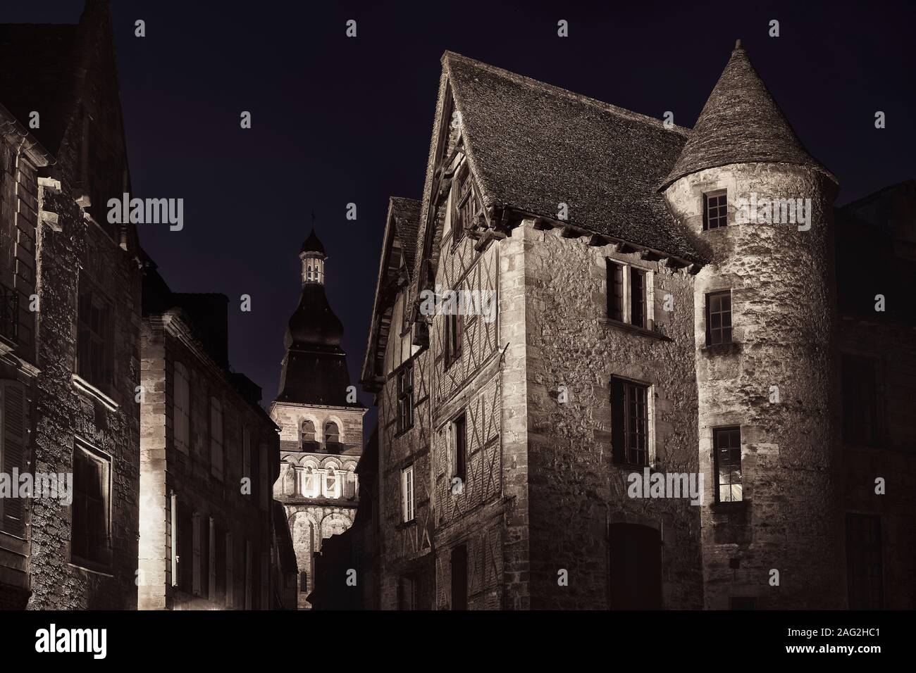 Schmale leere Alte Straße in einer mittelalterlichen Stadt in Frankreich, beleuchtet von einer Straßenlaterne in der Nacht. Dramatische nächtliche Kunst Landschaft. Schwarzweiß, Sepia getont Stockfoto