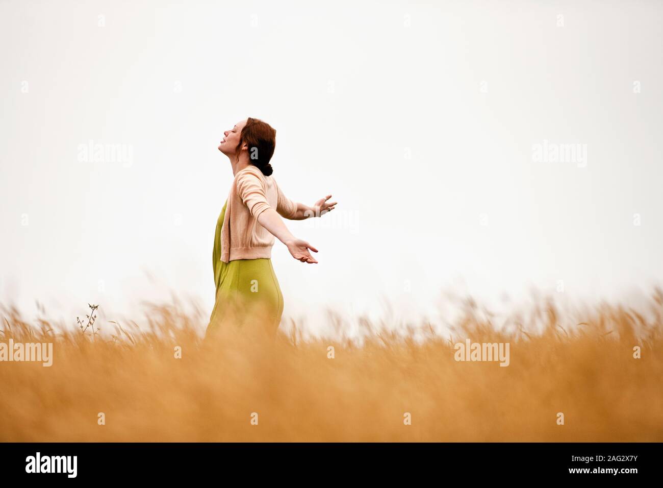 Junges Mädchen spinnen im Weizenfeld. Stockfoto