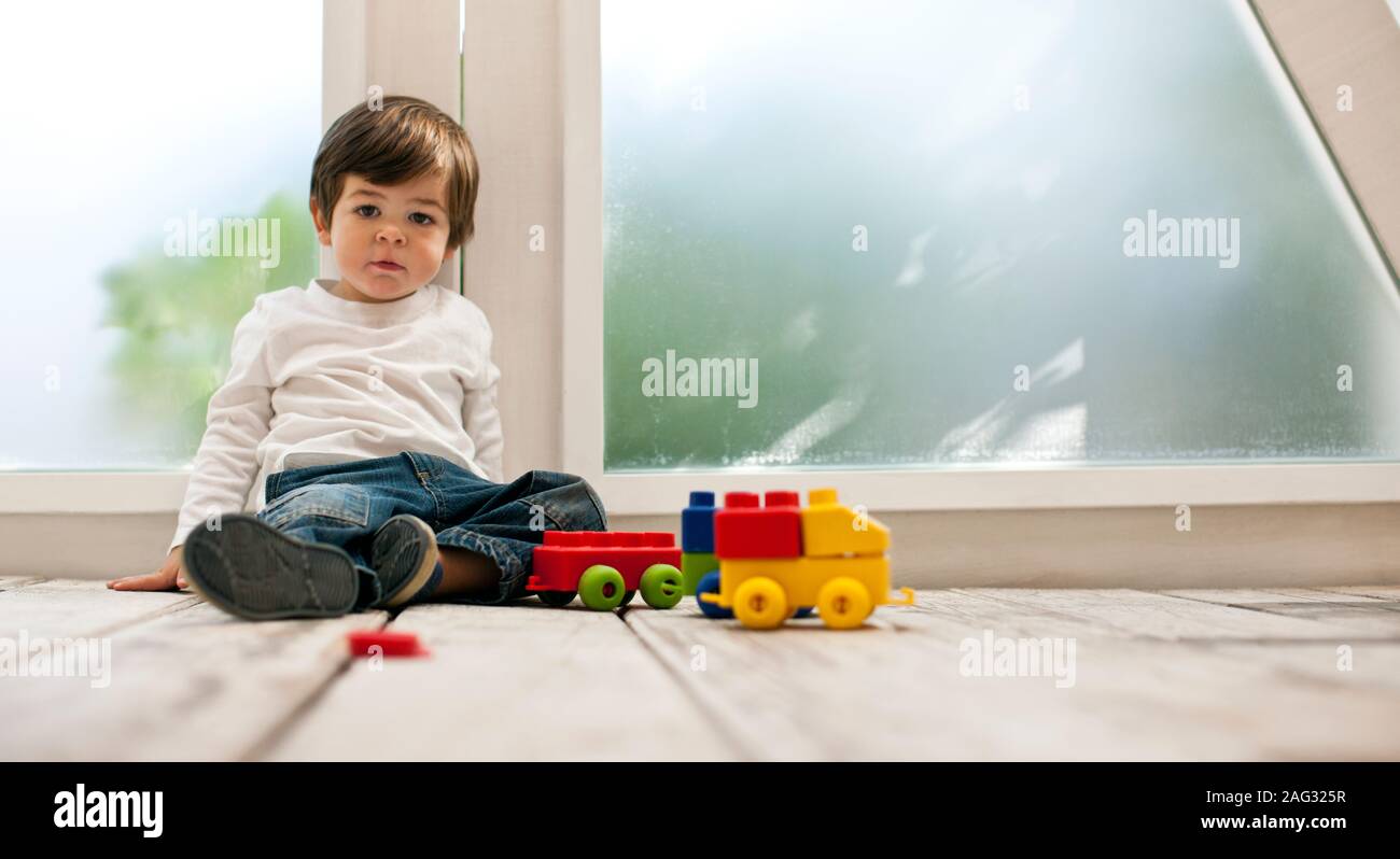 Kleinkind Junge spielt mit Bausteinen auf dem Boden. Stockfoto