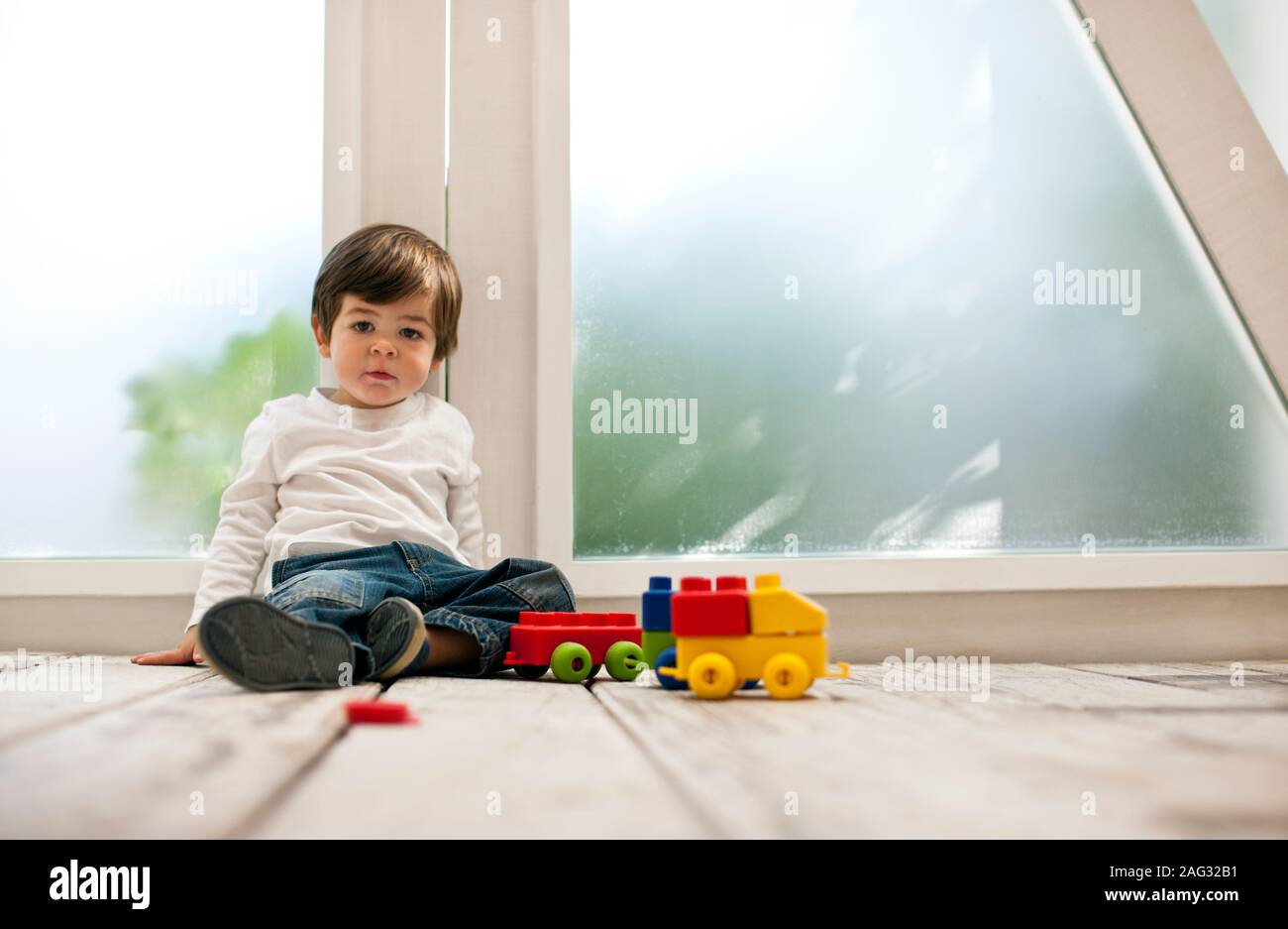 Kleinkind Junge spielt mit Bausteinen auf dem Boden. Stockfoto