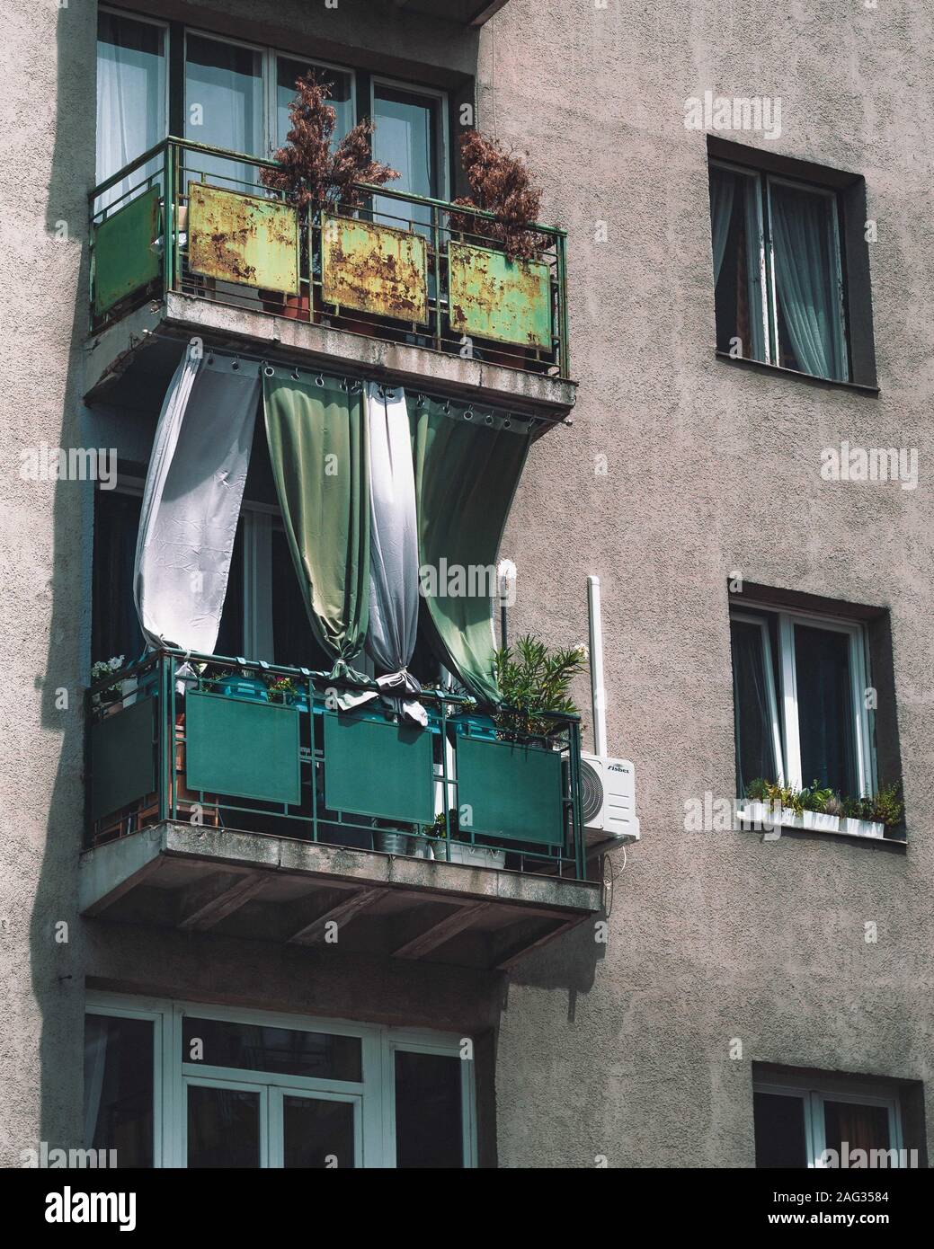 Balkone mit fließenden Vorhängen und verschiedenen Pflanzen, die die Fenster  bedecken Stockfotografie - Alamy
