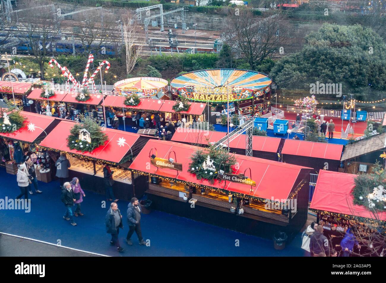 Teil der Weihnachtsmarkt und einige der Fahrgeschäften, die Teil von Edinburgh's Weihnachten im Osten die Princes Street Gardens. Zwei enthält werden auf dem Hauptbahnhof Linie oben im Foto, waltzers und ein Karussell in der Mitte und in Richtung der Vorderseite des Bild und an der Vorderseite des Bildes sind einige der Stände des Weihnachtsmarktes verkaufen Geschenke, Glühwein, heiße Schokolade usw. Die Leute wandern zwischen und brosing an den Marktständen. Stockfoto