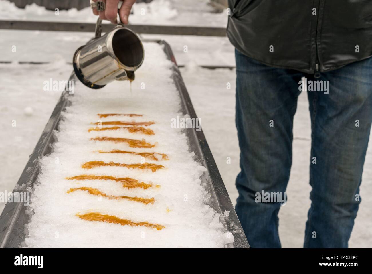 Ahornsirup ist auf frischem Eis gegossen, einem traditionellen Sugar Shack Dessert in Québec, Kanada zu machen. Stockfoto