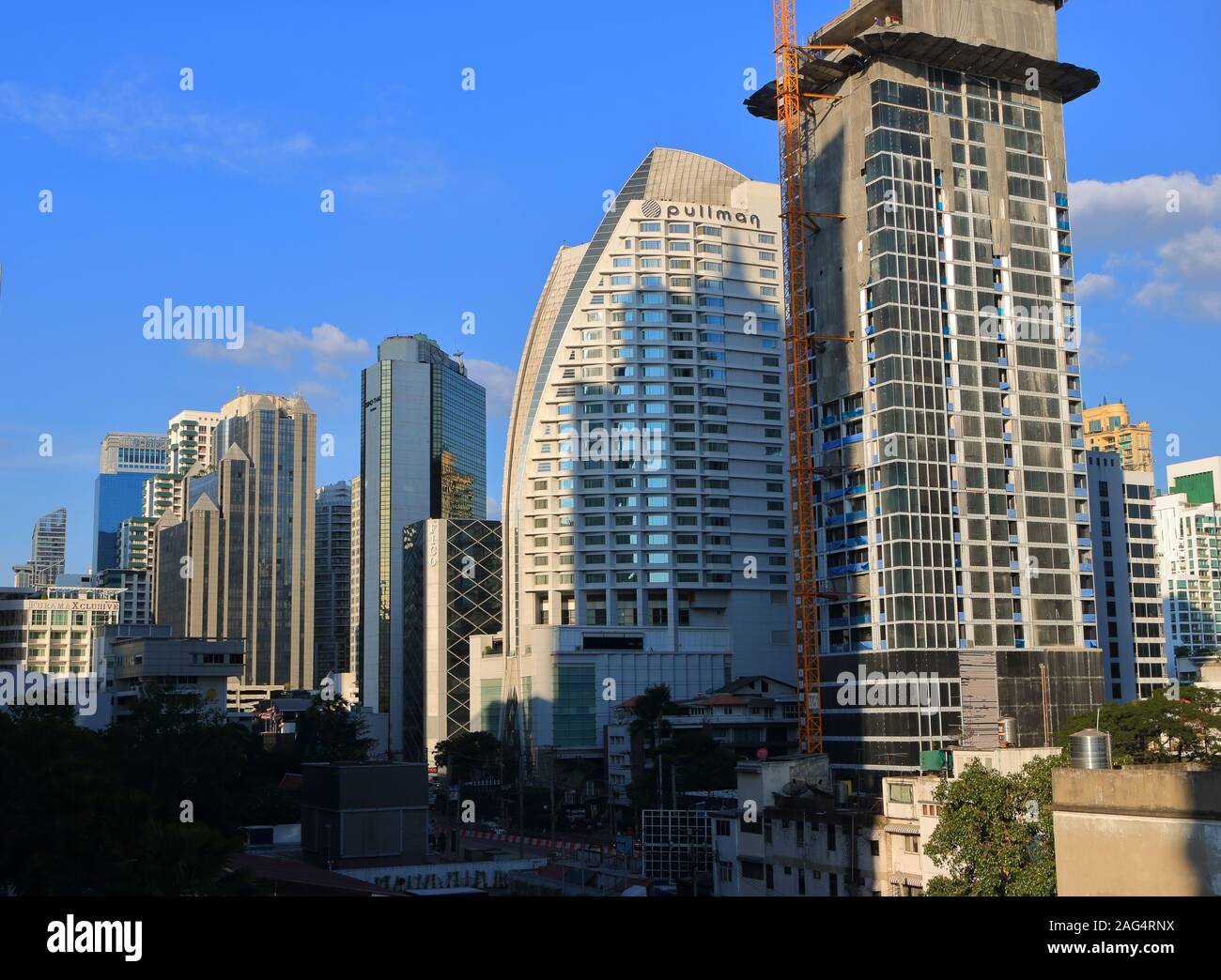 Bangkok, Thailand - 16 Dezember, 2019: Stadtbild am Asoke zeigt Pullman Sukhumvit Hotel neben dem im Bau befindlichen Gebäude amomg viele Wolkenkratzer Stockfoto