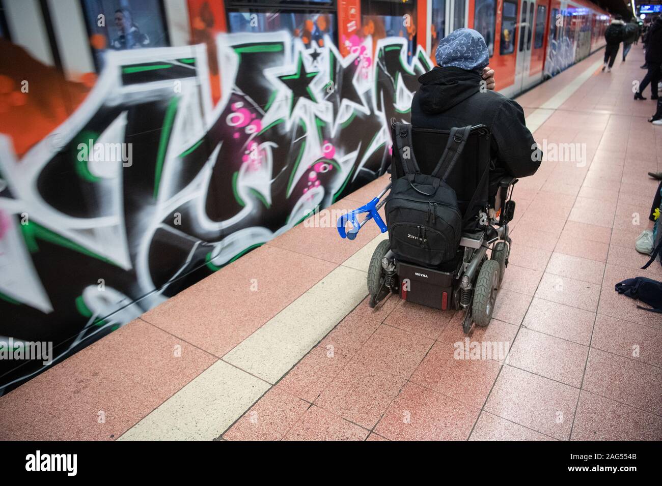 Stuttgart, Deutschland. 17 Dez, 2019. Steffen Gödecke Antriebe mit seinen elektrischen Rollstuhl hinter einer S-Bahn Station im Hauptbahnhof. Auf einer Pressekonferenz am 18. Dezember, die wichtigsten Punkte der staatlichen Initiative "Bahnhof der Zukunft" vorgestellt werden. Ziel der Initiative ist es, Bahnhöfe in Barrierefreie Mobilität Hubs zu entwickeln. Credit: Marijan Murat/dpa/Alamy leben Nachrichten Stockfoto