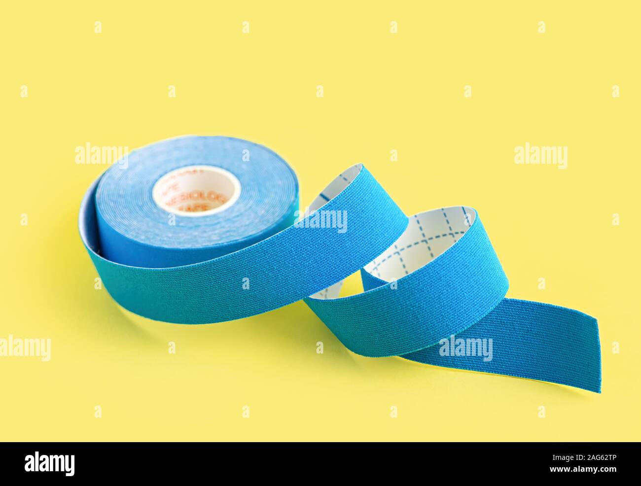 Blau Kinesiologie Tape auf gelbem Hintergrund. Physiotherapie tape Schmerzen und Verspannungen zu lindern. Alternative Medizin Konzept. Close Up. Stockfoto