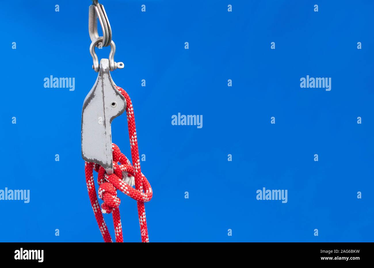 Nautische Knoten auf roten Seilen und Bekämpfung einer Yacht auf Blue Background. Große Kopie - Platz für die Platzierung von Text. Stockfoto