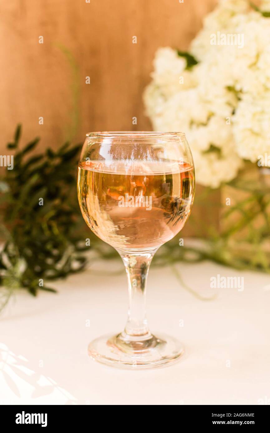 Rose Blush Wein in Gläsern. Flasche Rosewein mit Blumen auf Hintergrund. Prosecco. Stockfoto