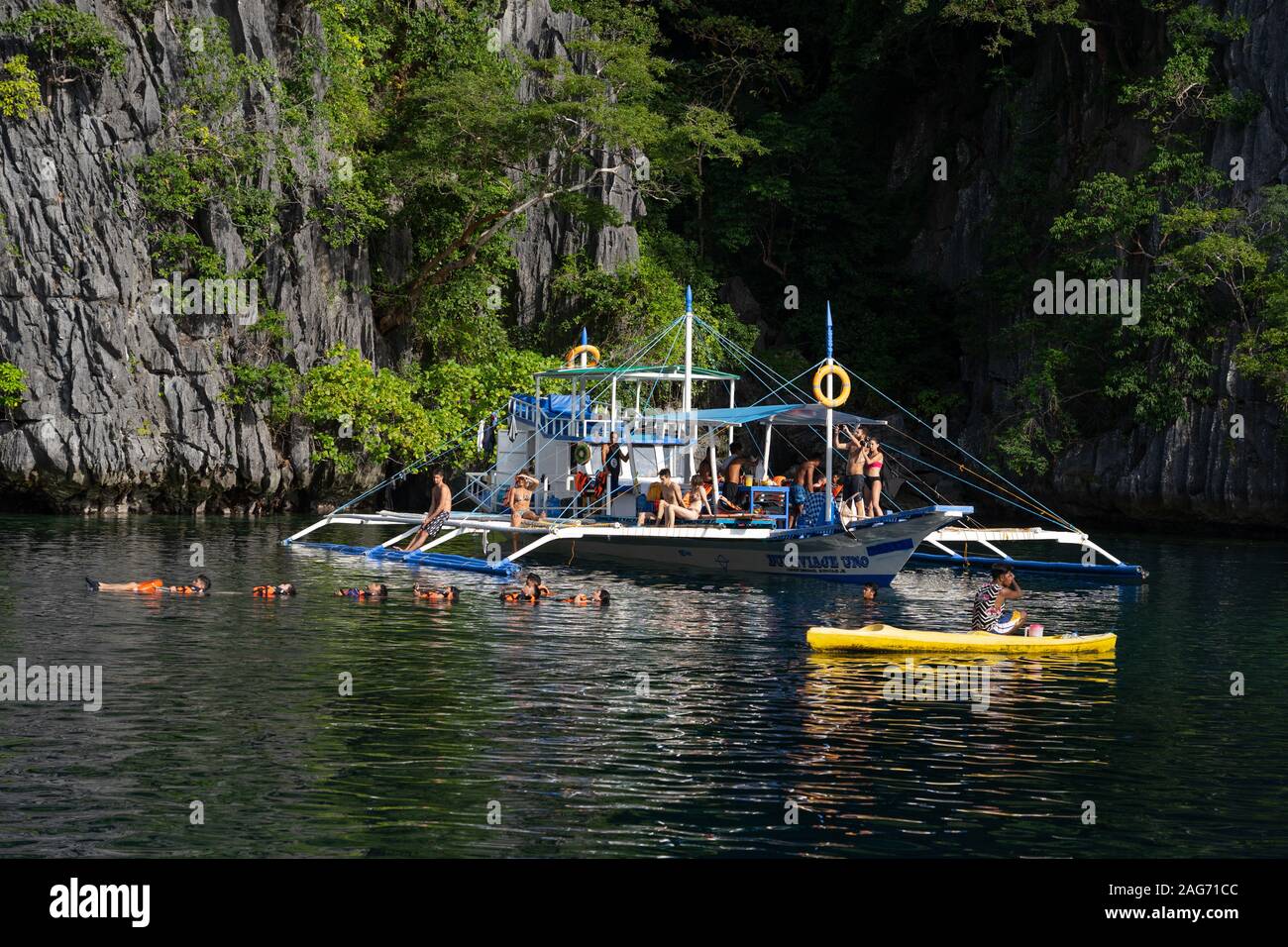 Tagesausflügler an Bord einer traditionellen Auslegerboot auf Island Hopping Touren, Coron, Philippinen verwendet Stockfoto