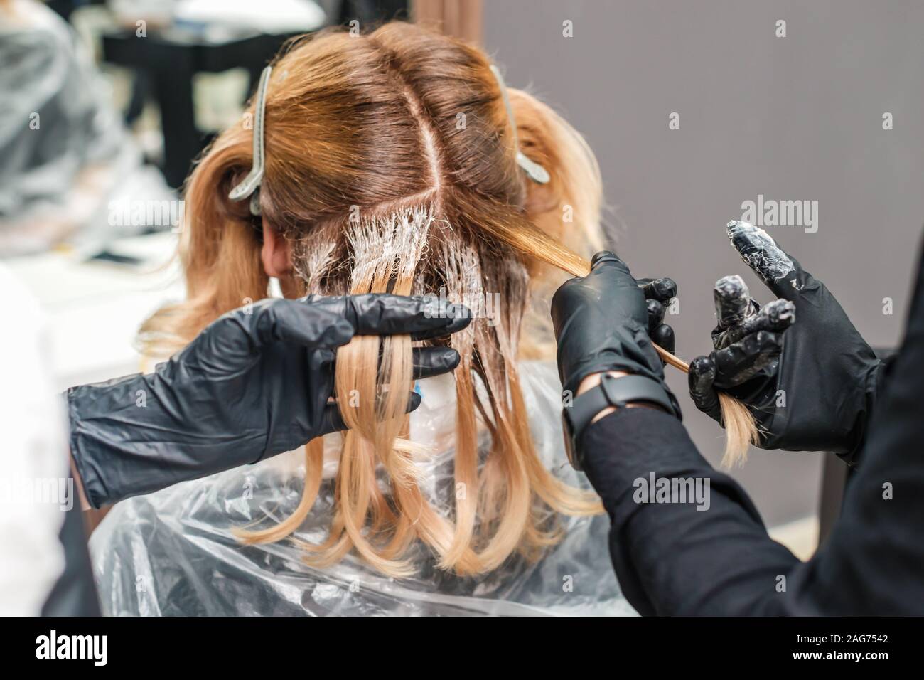 Hände in schwarz Handschuhe Färbung einer Frau Haar im Salon, Haare färben. Stockfoto