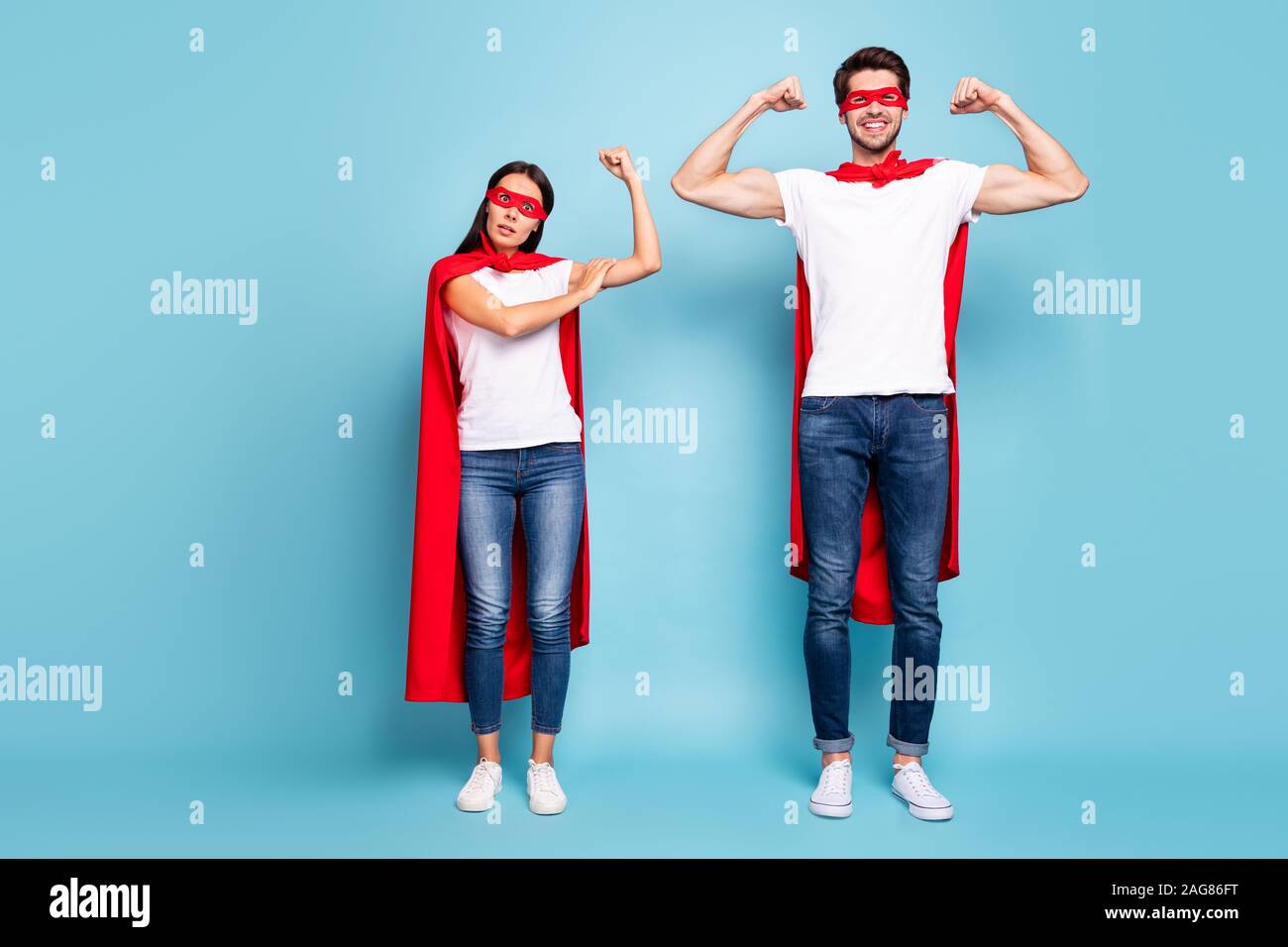 Volle Länge Körper Größe Blick auf Nizza wettbewerbsfähige Fröhliche sportliche Leute in Rot hero Suchen Übersicht arm Muskulatur schwache weibliche Geschlecht männlich auf isolierte vs. Stockfoto