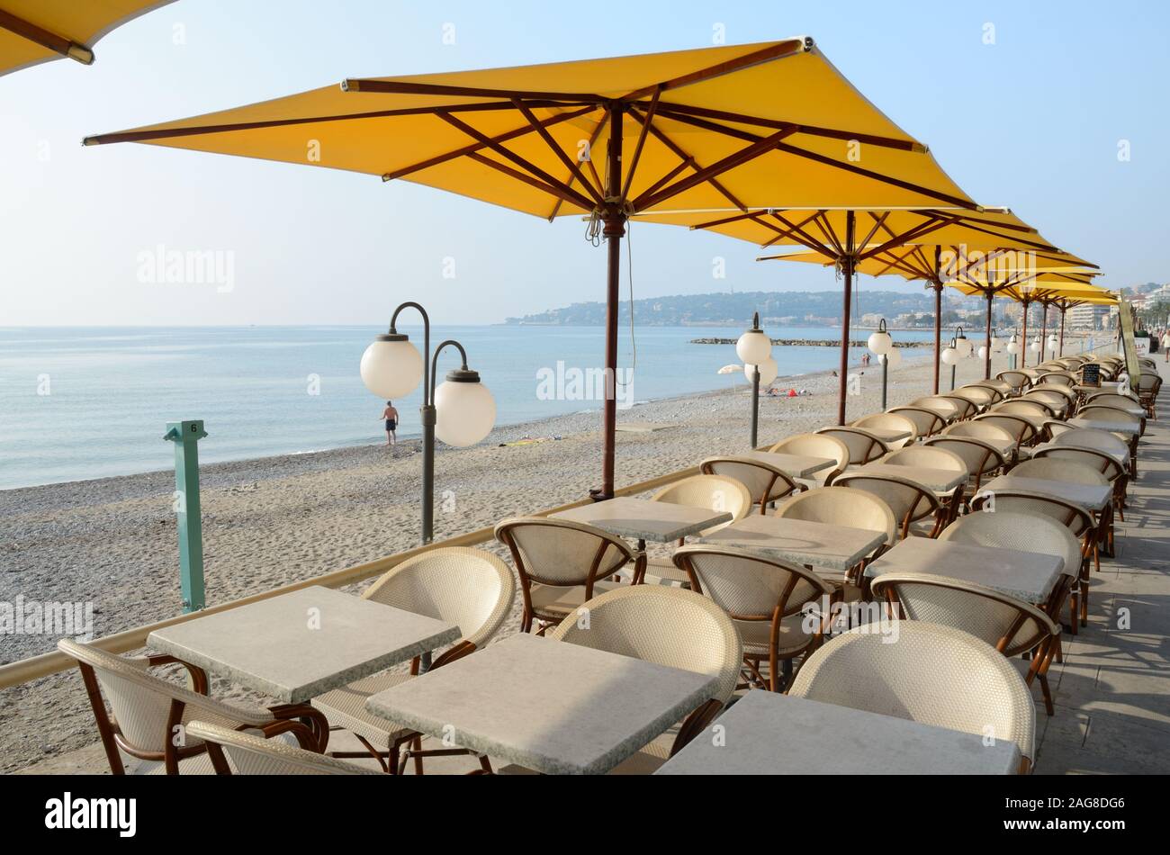 Strand & Leere Restaurants am Meer, Tische, Stühle und Sonnenschirme Menton Côte d'Azur Frankreich Stockfoto