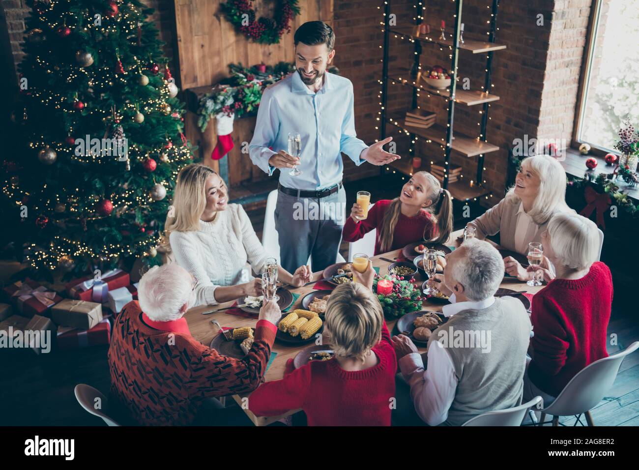Foto von großen Familientreffen sitzen Tisch Vater Kerl sagt x-mas Toast schätzen multi-generation Reunion in Neujahr Atmosphäre Wohnzimmer Stockfoto