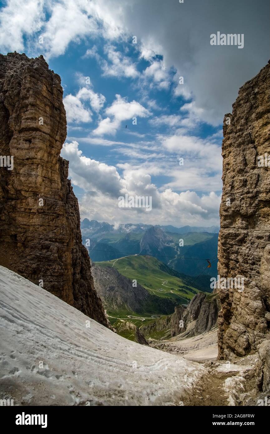 Eine Person ist zu Fuß auf der slackline zwischen den Felsen des Plateaus Sass Pordoi, gebirgigen Dolomiti Landschaft in der Ferne Stockfoto