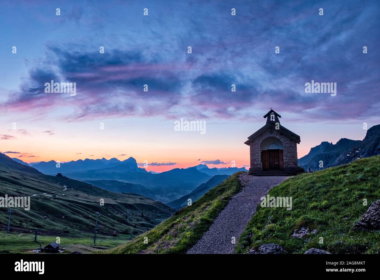 Eine kleine Kapelle in der Nähe von Pordoi Pass, Passo Pordoi bei Sonnenaufgang, der Setsas Berge in der Ferne Stockfoto