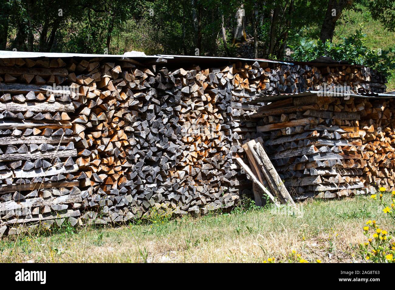 In einem Garten Montriond Portes du Soleil France Wurden In Den Wintermonaten bedeckte Holzhaufen Für Brennholz und brennendes Brennholz verwendet, um Wärme Zu Geben Stockfoto