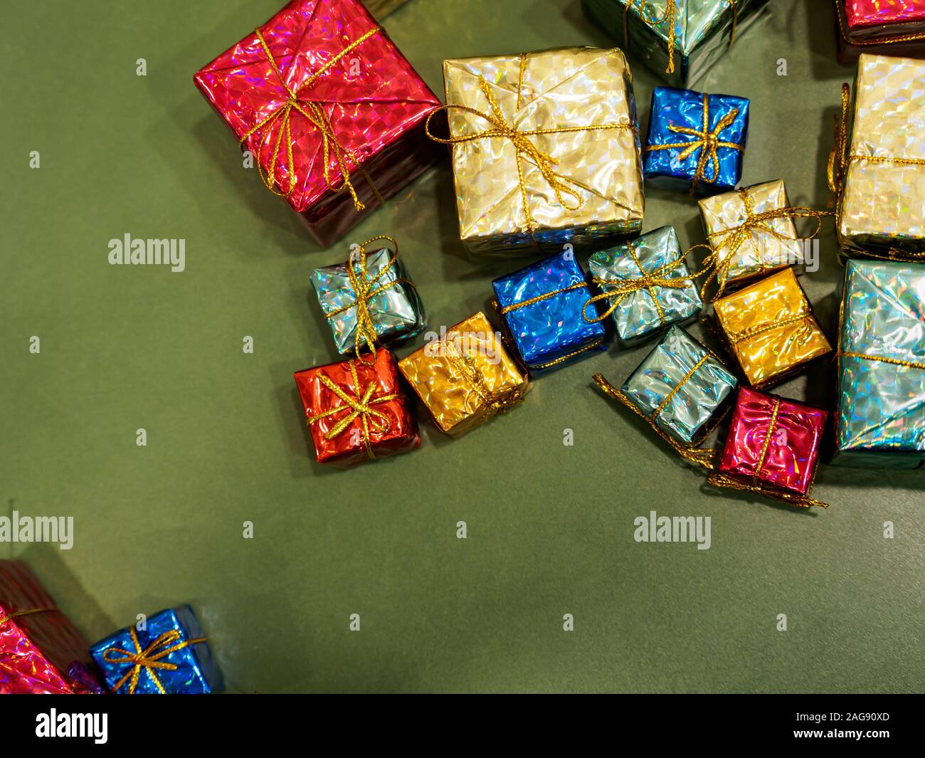 Flach der sortierten präsentiert in glänzendes Papier und Bändern auf einem grünen Hintergrund gewickelt. Weihnachten / Weihnachten/Geburtstag Geschenke Thema Stockfoto