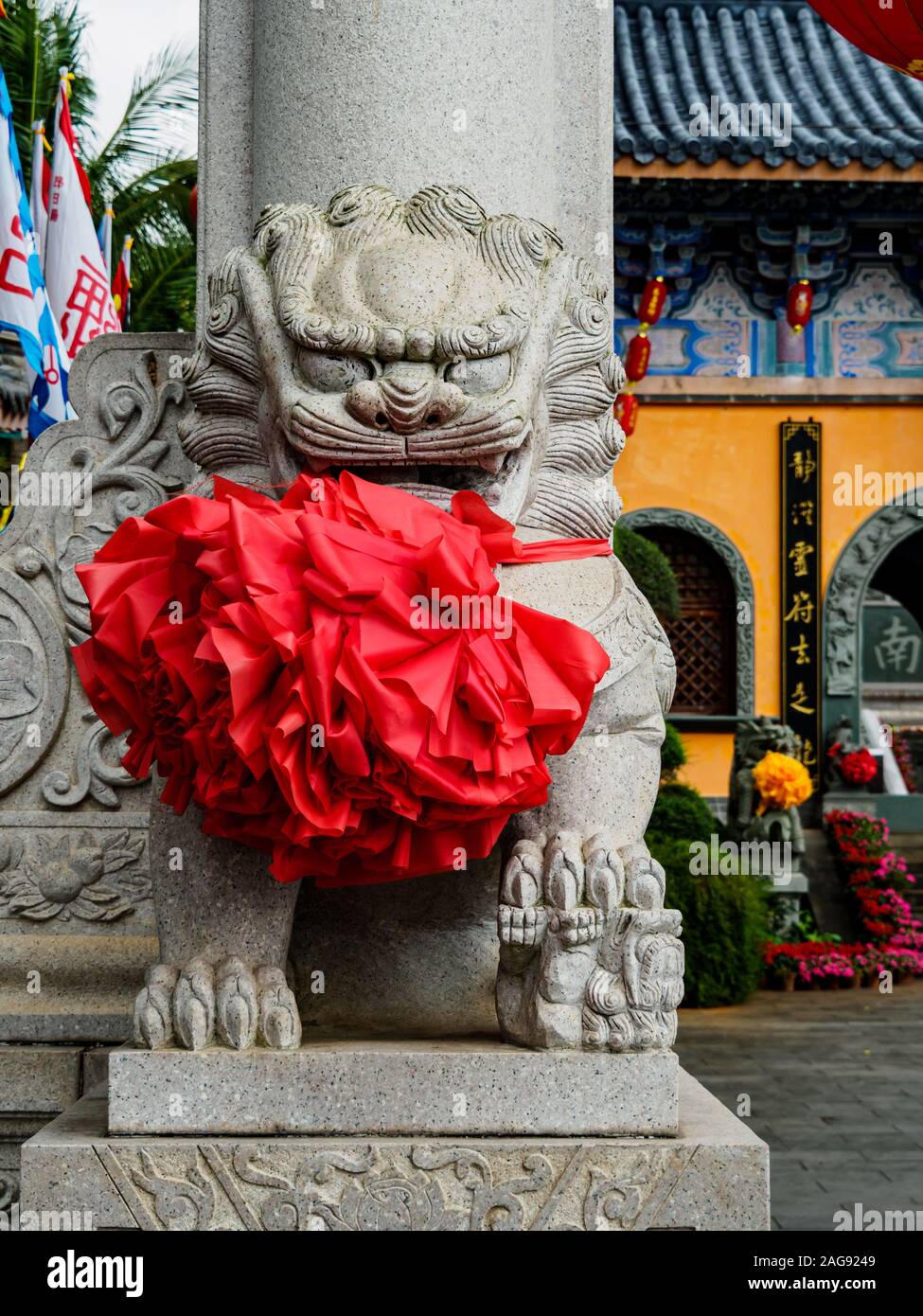 Imposante chinesische Stein guardian Lion am Eingang eines chinesischen Tempel in Hainan, China. Der Löwe ist Scharren eine Kugel, die Signalisierung der Oberhoheit über die wo Stockfoto