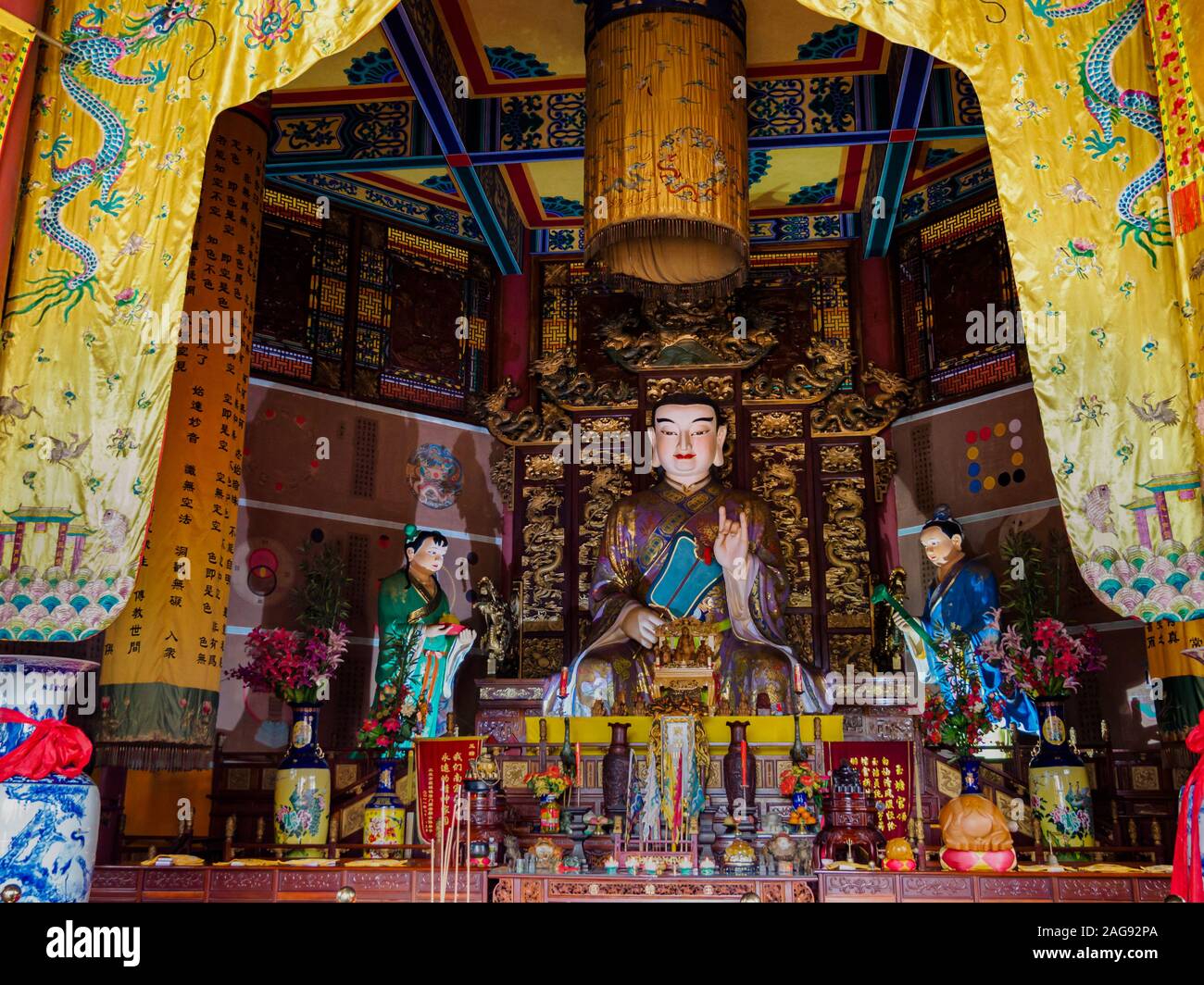 Kunstvoll geschnitzt und verziert Statue von Buddha in einem taoistischen Tempel in Wen Bi Feng, Hainan, China Stockfoto