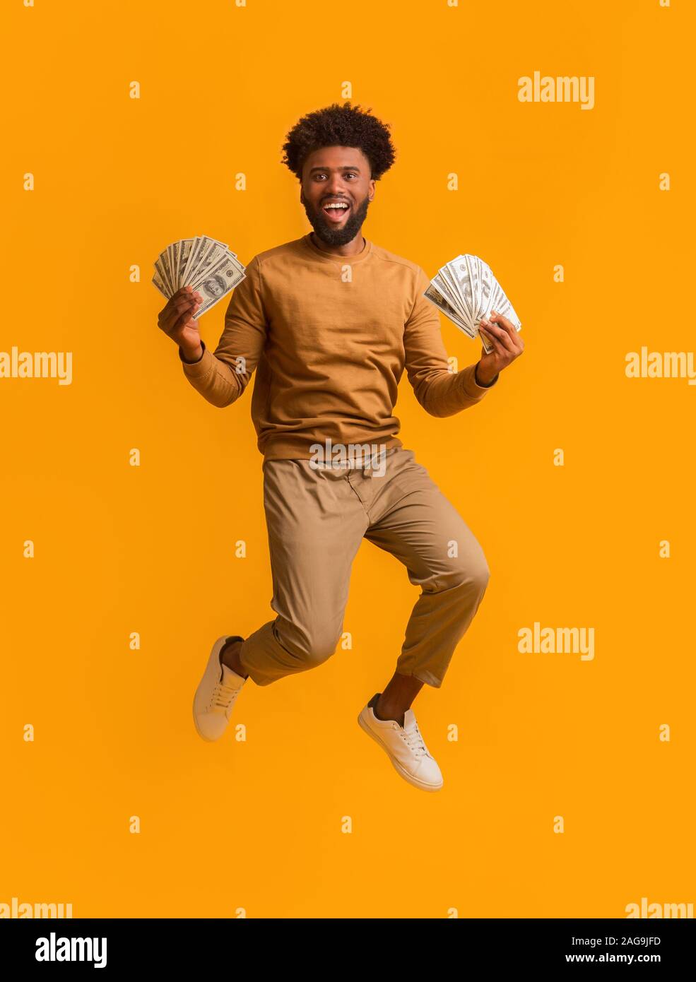 Super glücklich afro Kerl Sieg feiern, viel Geld Stockfoto
