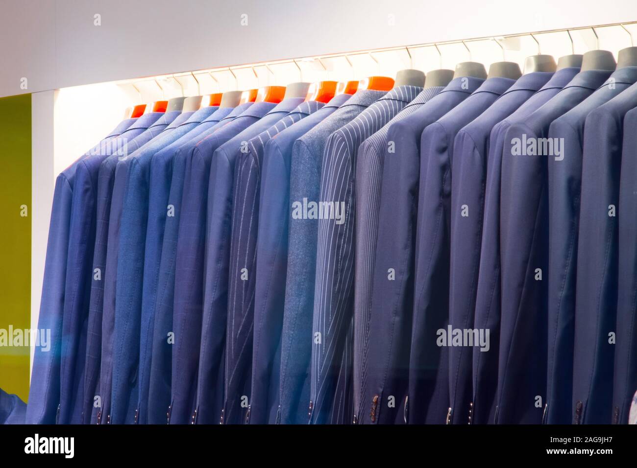 Eine Reihe von Jacken für Männer auf einem Kleiderbügel in einem Bekleidungsgeschäft Stockfoto