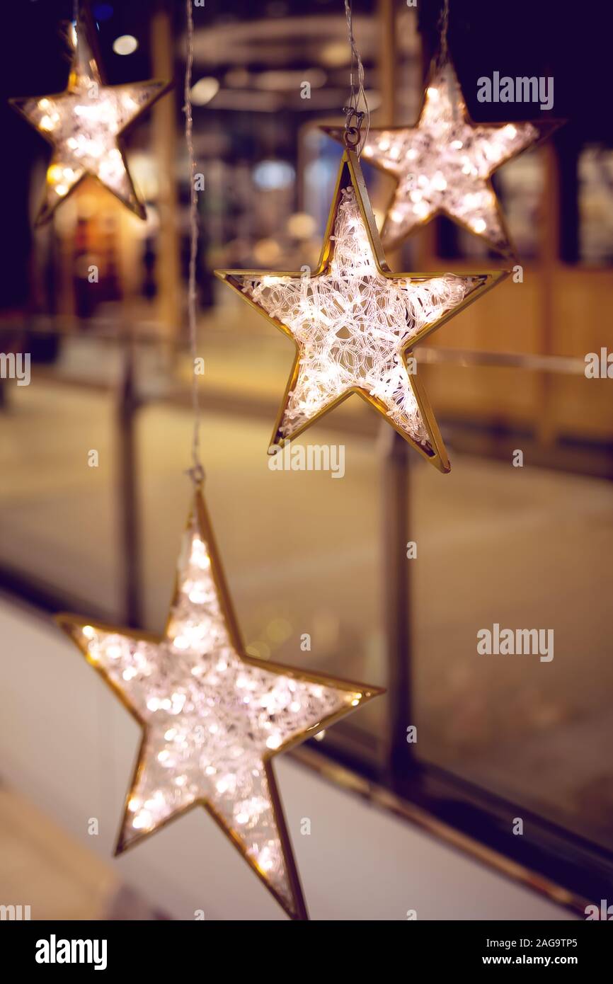 Dekorative Sterne mit Beleuchtung. Weihnachten Hintergrund mit Sternen und Garland in einer City Shopping Mall Stockfoto