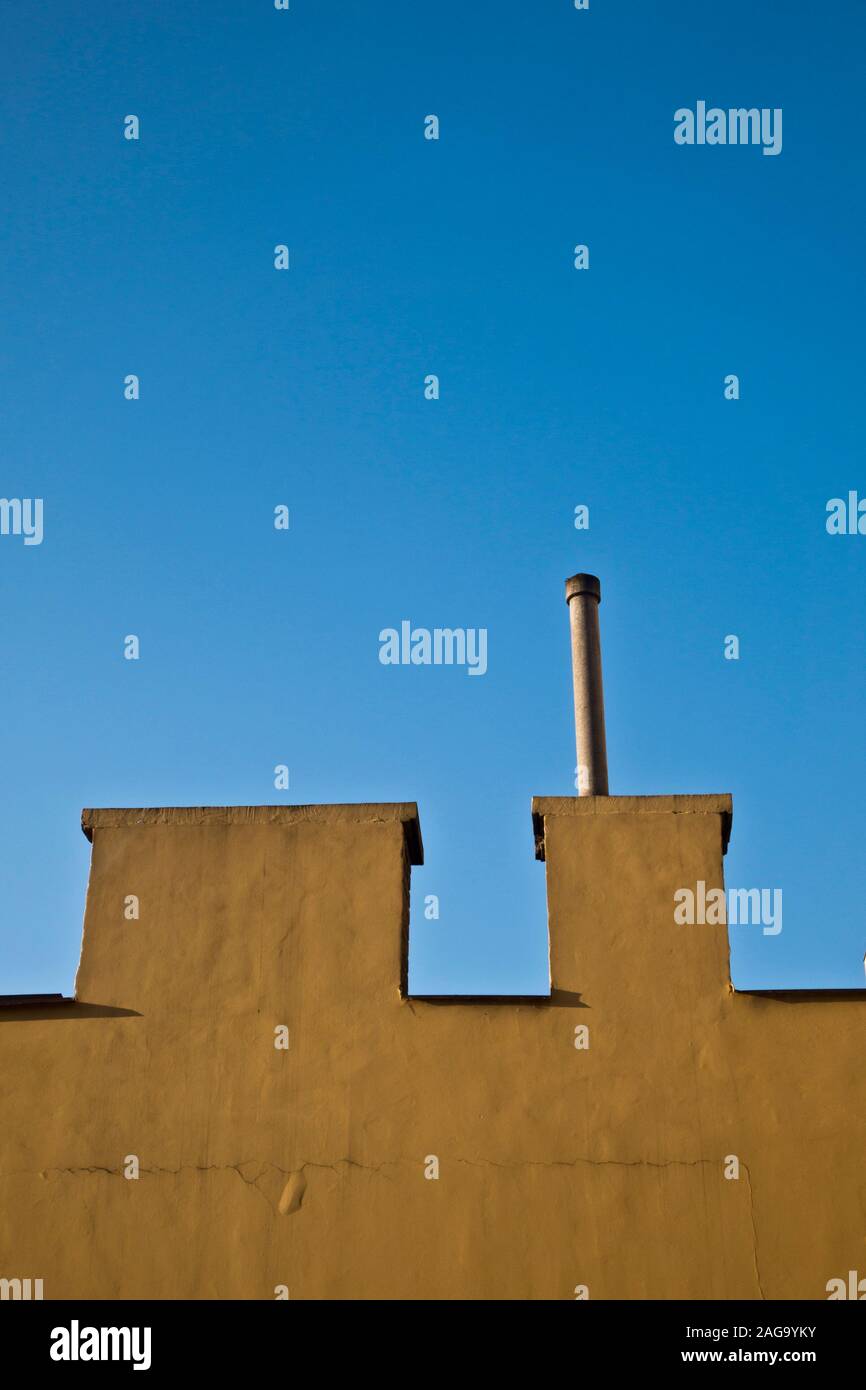 Minimalistisches architektonisches Detail eines gelben Gebäudes und blauen Himmel Stockfoto