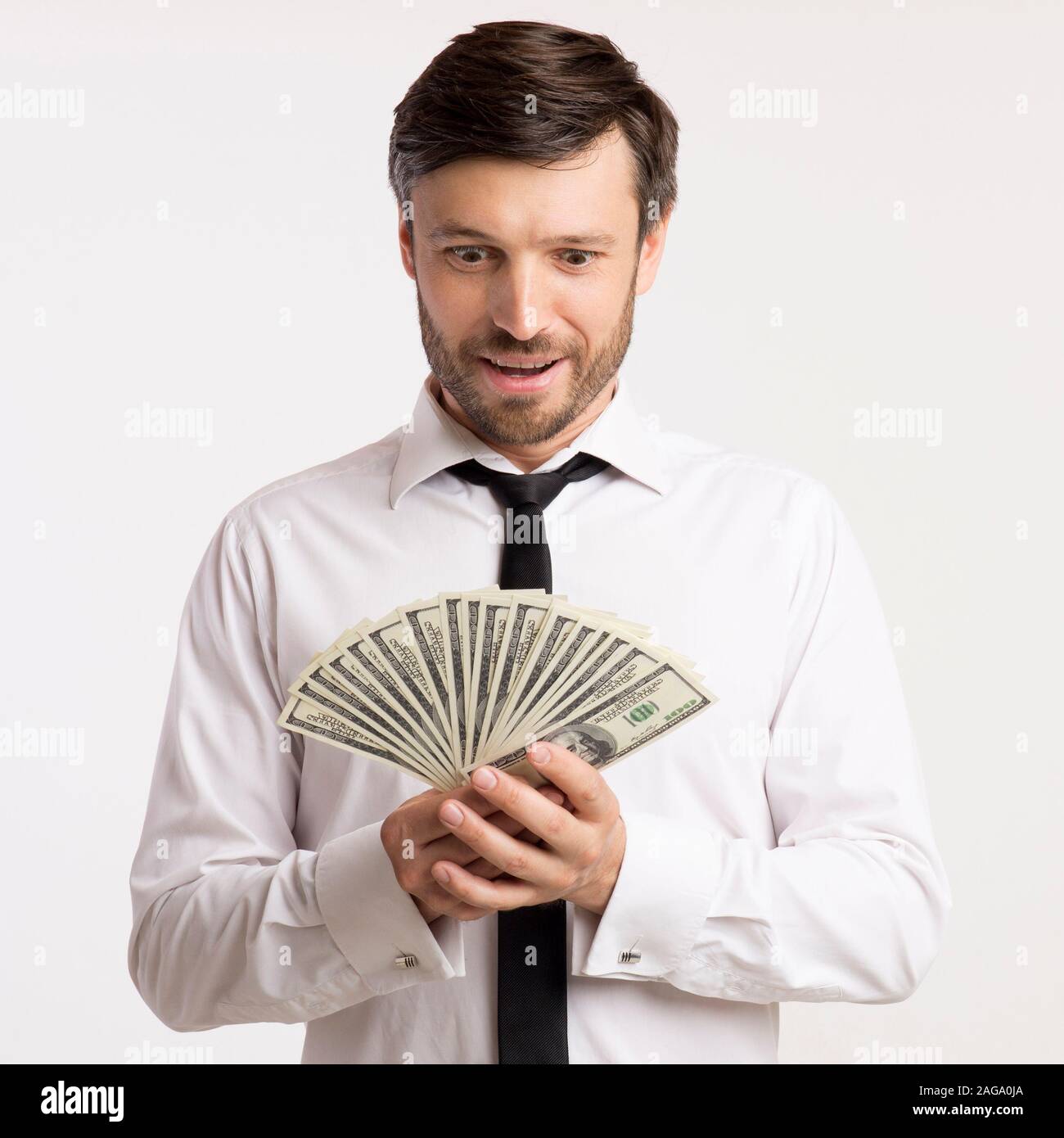 Unternehmer auf der Suche nach Bargeld in Händen, die auf weißem Hintergrund Stockfoto