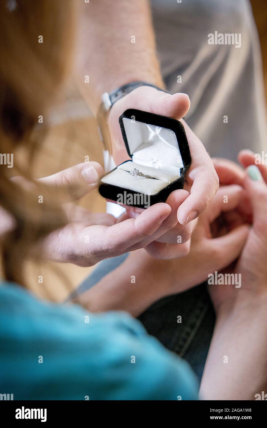 Vertikale Aufnahme eines Mannes, der einen Promise-Ring gibt Seine Freundin Stockfoto