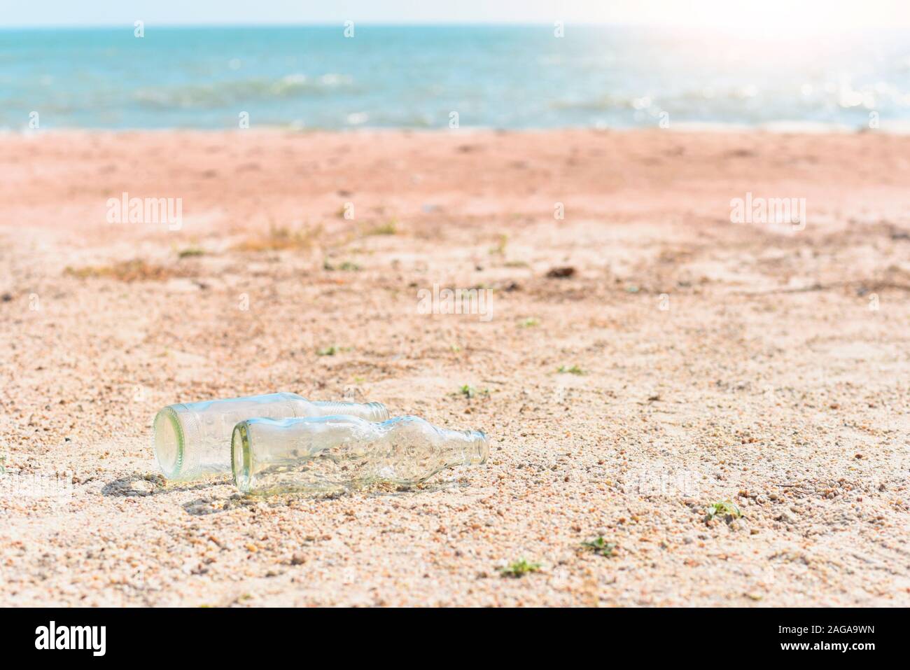 Glasflaschen auf Sandstrand wie für Umweltverschmutzung von Meer Konzept isoliert Stockfoto