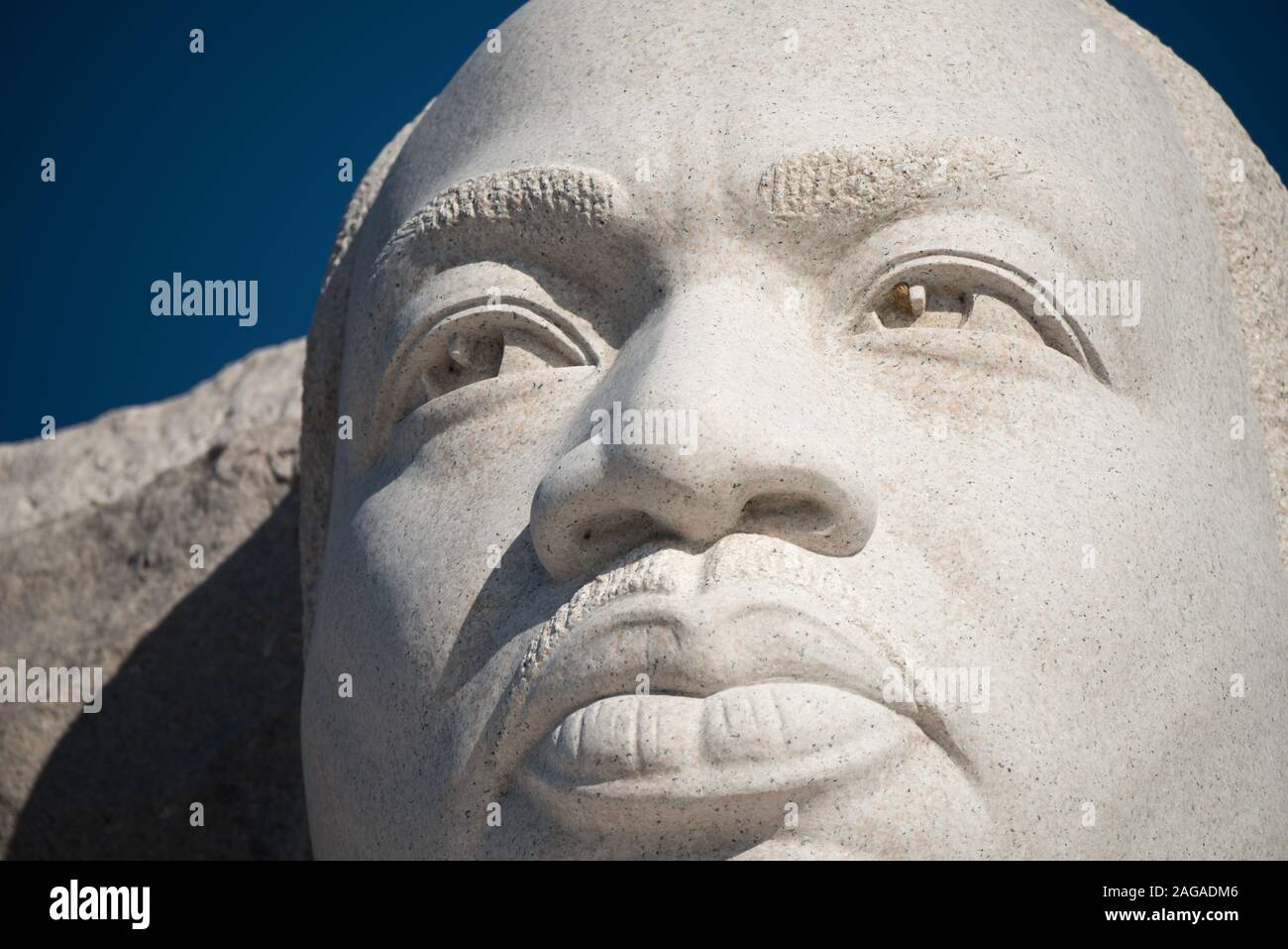 Martin Luther King Jr Memorial Statue Washington DC / WASHINGTON DC – die zentrale Statue von Dr. Martin Luther King Jr. erhebt sich aus dem Stein der Hoffnung am Martin Luther King Jr. Memorial. Das vom chinesischen Bildhauer Lei Yixin entworfene 30 Meter hohe Bild ist aus weißem Granit geschnitzt. Die Zahl des Bürgerrechtlers scheint aus dem Stein zu steigen, die Arme überkreuzt und nach vorne blickt. Stockfoto