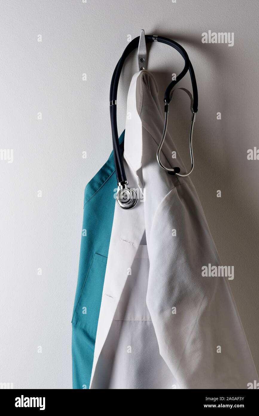 Ein Ärzte weißen Labormantel und grünen Büschen Hängen an einen Haken mit Stethoskop. Stockfoto